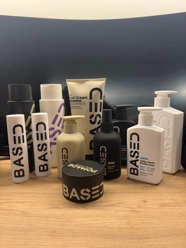 Customer's collection of various Based Bodyworks hair and body products displayed on a wooden surface.