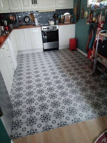 En kundes kjøkken med dekorative Copenhagen selvklebende fliser lagt på gulvet.