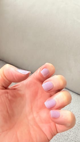 Customer's hand showing off neat, shimmery purple nails applied using the Holy Gels Starter Kit.