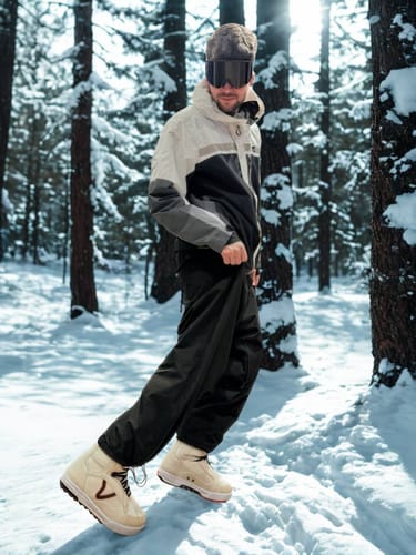 Reviewer wearing baggy, black Drawstring Snow Pants in a snowy forest.