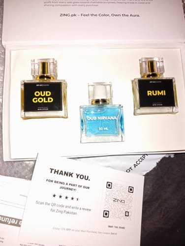 Reviewer showing the three different perfume bottles from the OUD Supreme BUNDLE inside the open product box.