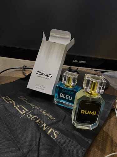 Customer's 'Rumi' and 'Bleu' fragrances with their white box and a black Zing Scents bag.
