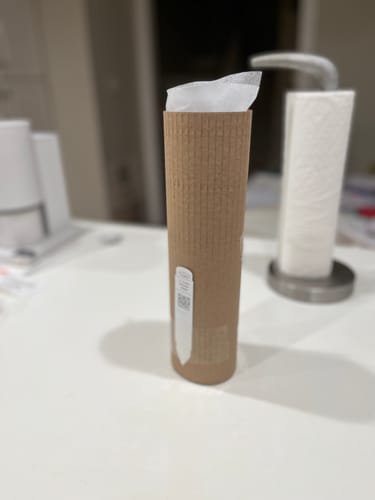 Packaging for customer's Hoya cumingiana, a plant in a protective cardboard tube on a white counter.