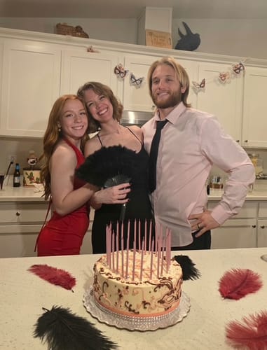 Reviewer and friends pose behind a birthday cake during their Masquerade Ball Murder Mystery party.