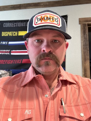 Reviewer wearing a grey and white Snapback Hose Hat with a "TATUM FD" patch on the front.