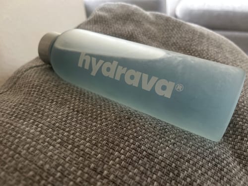 Customer's light blue Electrolyte Salts drink prepared in a reusable water bottle and resting on a couch.