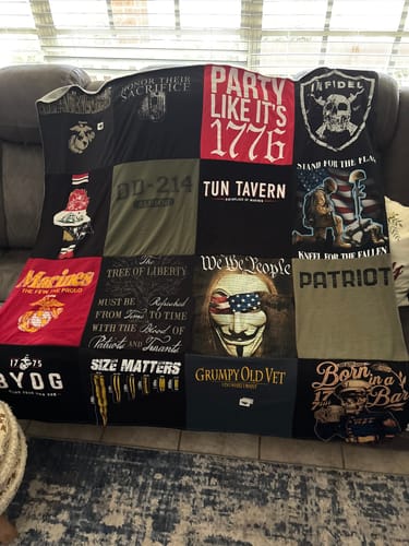 A customer's memorial Premium T Shirt Quilt, made with U.S. Marine and patriotic shirts, draped on a couch.