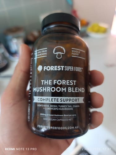 Customer holding the brown bottle of The Forest Mushroom Blend supplement.