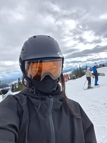Reviewer in the black insulated snow jacket and ski gear on a snowy mountain.