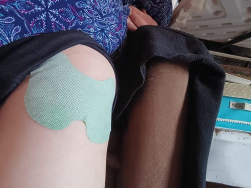 Cliente con el parche verde para rodilla aplicado en la pierna.