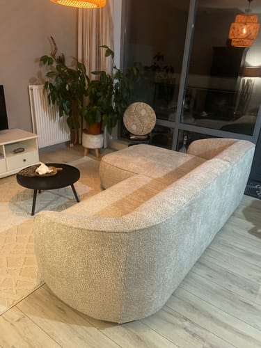 Klant toont de by fonQ Chubby hoekbank in bouclé greige stof in een woonkamer.
