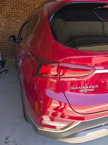 Customer's shiny red car showing a clean, reflective finish after using the Madness Kit.