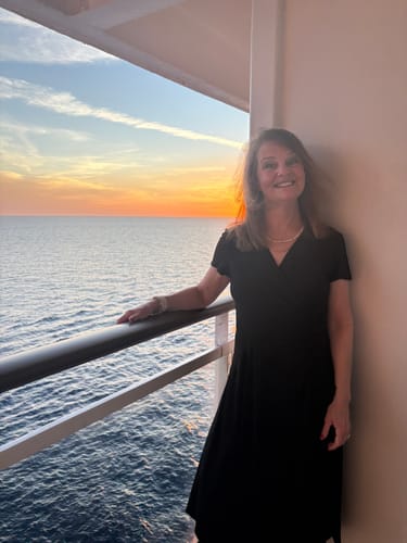 Reviewer wearing the Aloha Pearl and Gold Choker on a balcony with a sunset over the ocean.