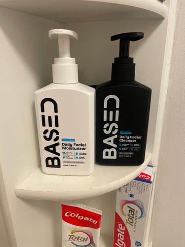 Customer's Daily Skincare Duo bottles, one white and one black, sitting on a bathroom shelf.