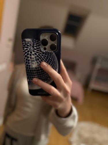 Reviewer holding their phone in a mirror, showing the back of the blue Studio 54 tough iPhone case.