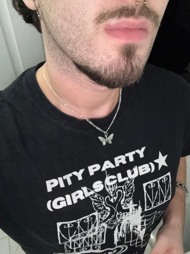 Reviewer wearing the shiny 3mm Sterling Silver Figaro Chain with a small butterfly pendant.
