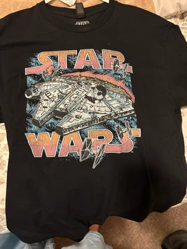 Customer's black Vintage Millennium Falcon t-shirt laid flat, showing the colorful retro graphic.