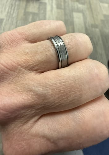 Reviewer's hand wearing The Atlas, a silver-colored ring with a distinct hammered texture.