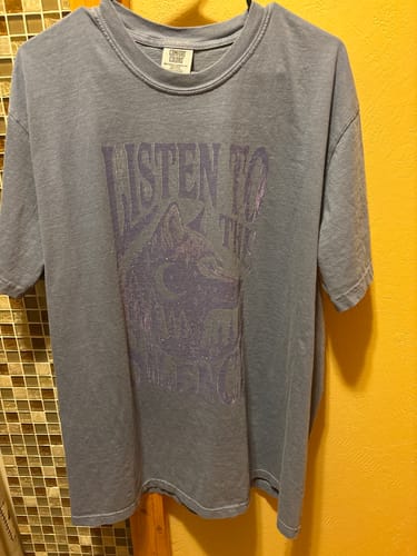 Customer's blue Silence T-shirt with a purple wolf graphic and 'Listen to the' text.