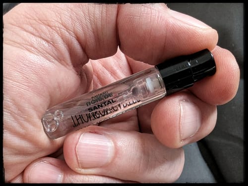 Customer holding the small glass Bois De Santal Eau de Parfum tester in their palm.