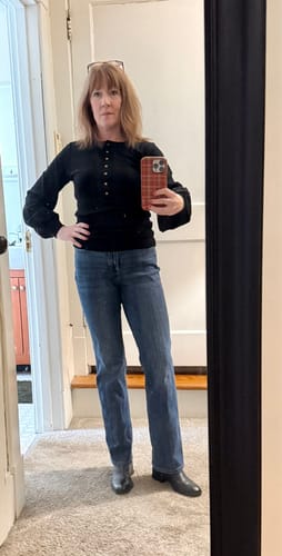 Reviewer in a mirror selfie wearing the black Charlotte Puff Sleeve Top with blue jeans.
