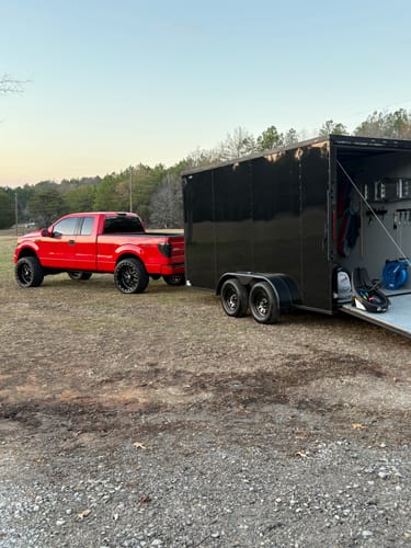 Reviewer's red truck hitched to a black trailer, mentioned in their review.