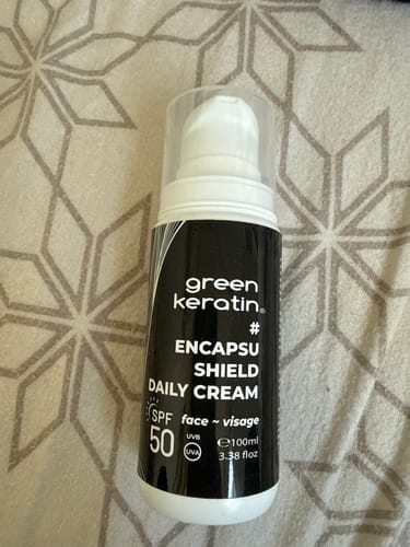 Photo d'un client du nouveau flacon noir et blanc de la crème ENCAPSUSHIELD SPF50.