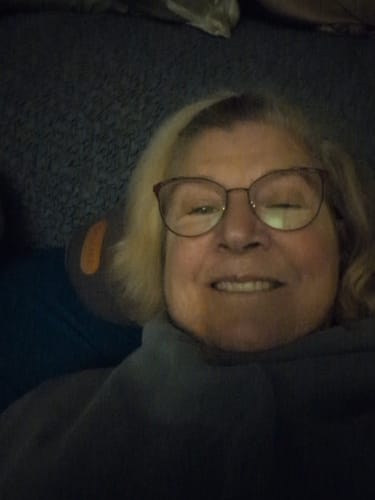 Reviewer smiling in a close-up while relaxing with the Original Callixe Thera Pillow.