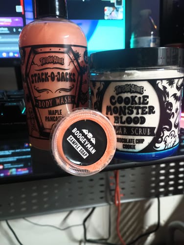 Customer's jar of Cookie Monster Blood Sugar Scrub sitting on a desk with other bath products from the same brand.