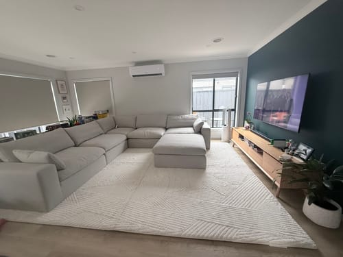 Customer's large Mellow Mat with a vector line pattern in their living room, placed under a sectional sofa.