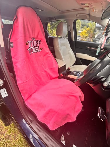 Customer's bright pink Waterproof Car Towel Seat Cover fitted on the driver's seat of a car.