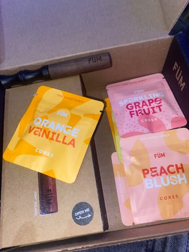 Customer's unboxing of a Füm device and assorted Core flavor packs including Orange Vanilla, Sparkling Grape Fruit, and Peach Blush.
