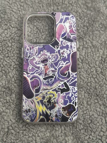 Customer's LUFFY GEAR 5 - ONE PIECE phone case with a purple and white anime design, seen on a grey fluffy surface.
