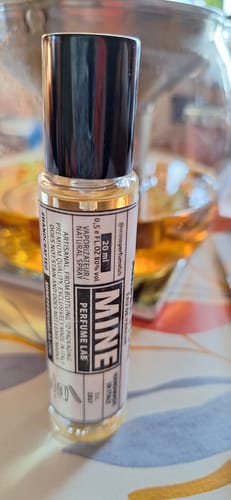 Recensore mostra un primo piano della boccetta trasparente del profumo Amberstone, con tappo nero.