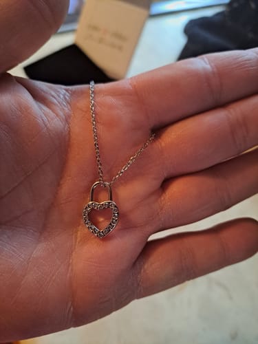 Customer holding the Janelle Heart Padlock Pendant Necklace in their palm, showing the sparkling crystal detail.