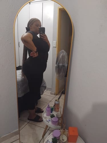 Customer's side profile showing a defined waist while wearing the 25 Steel Bone Latex Waist Trainer under a black outfit.