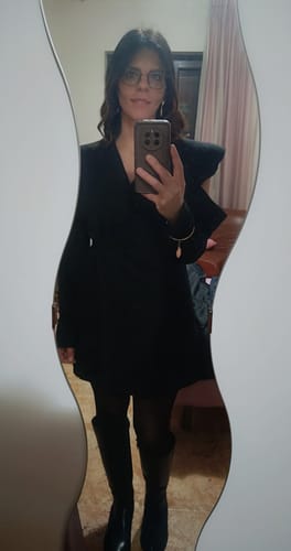 Recensore che posa allo specchio indossando l'Abito Blazer 722 nero con stivali alti.