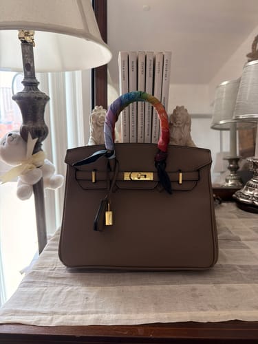Reviewer's taupe Warkin Bag with a colorful scarf on its handle, sitting on a dresser.