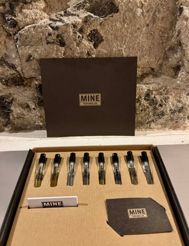 Recensore mostra il set di campioni orientali e legnosi aperto, con gli 8 profumi in fiala disposti ordinatamente.