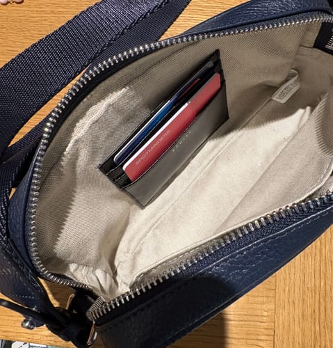 Customer's red SPOTMINDERS Tracking Card shown inside a card holder within a small navy purse.