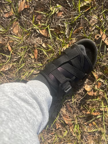 Customer wearing the black Original DracoSlides with multiple adjustable straps outdoors.