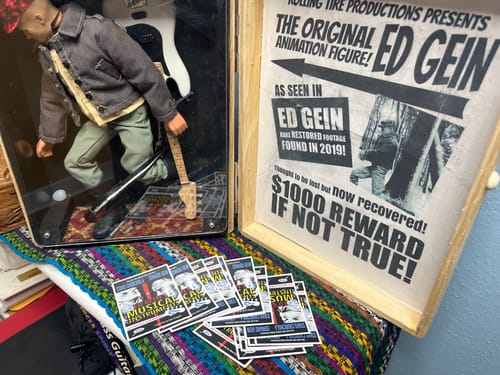 Reviewer's custom vinyl stickers promoting their film, displayed in front of an animation figure and poster.