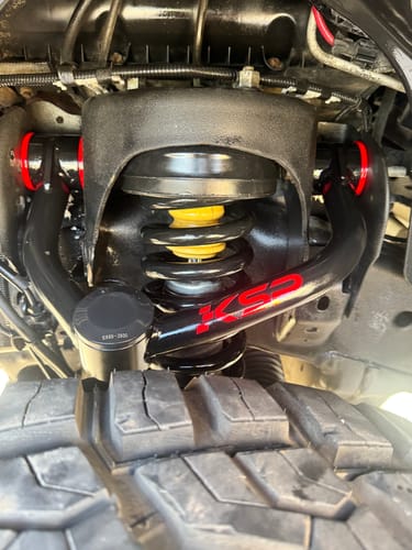 Customer's black Upper Control Arms with red bushings installed on their Ford F150.