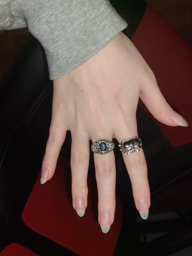 Customer's hand wearing the Triple Threat Ring on the ring finger, styled next to another silver ring.