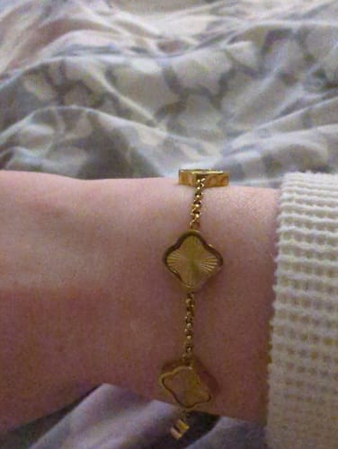 Customer's close-up view of the Celine Clover Bracelet in textured gold on their wrist.