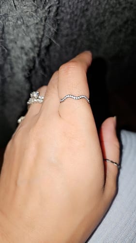 Close-up of a customer's hand wearing the Zenya Crystal & Silver Wave Ring on their index finger.