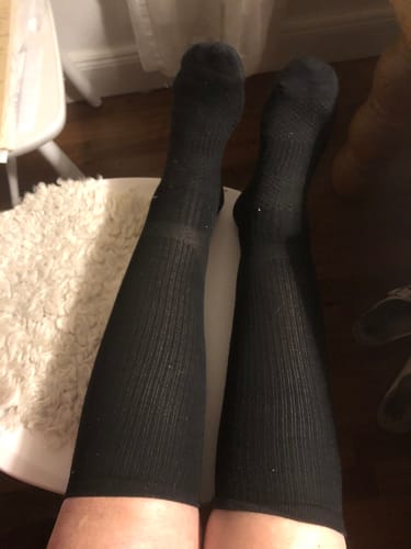 Recensent som sitter med fötterna uppe och visar sina svarta Diasocks Stödstrumpor.