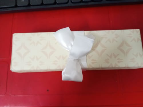 Customer's gift-wrapped box for the Silver Blue Evil Eye Anklet, tied with a white bow.