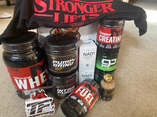 Reviewer's tub of Creatine Powder displayed with a collection of other MTS Nutrition supplement products.