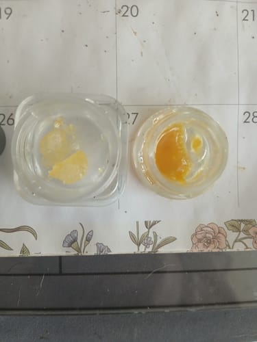 Customer's two small glass jars of Live Resin THCa Diamonds, showing a pale yellow and a rich golden concentrate side-by-side.